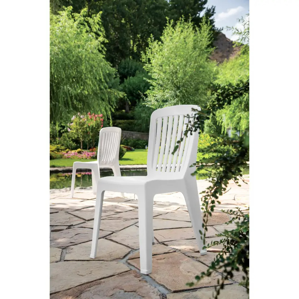 صندلی پلاستیکی باغی سفید و شیک در حیاط سبز و دنج